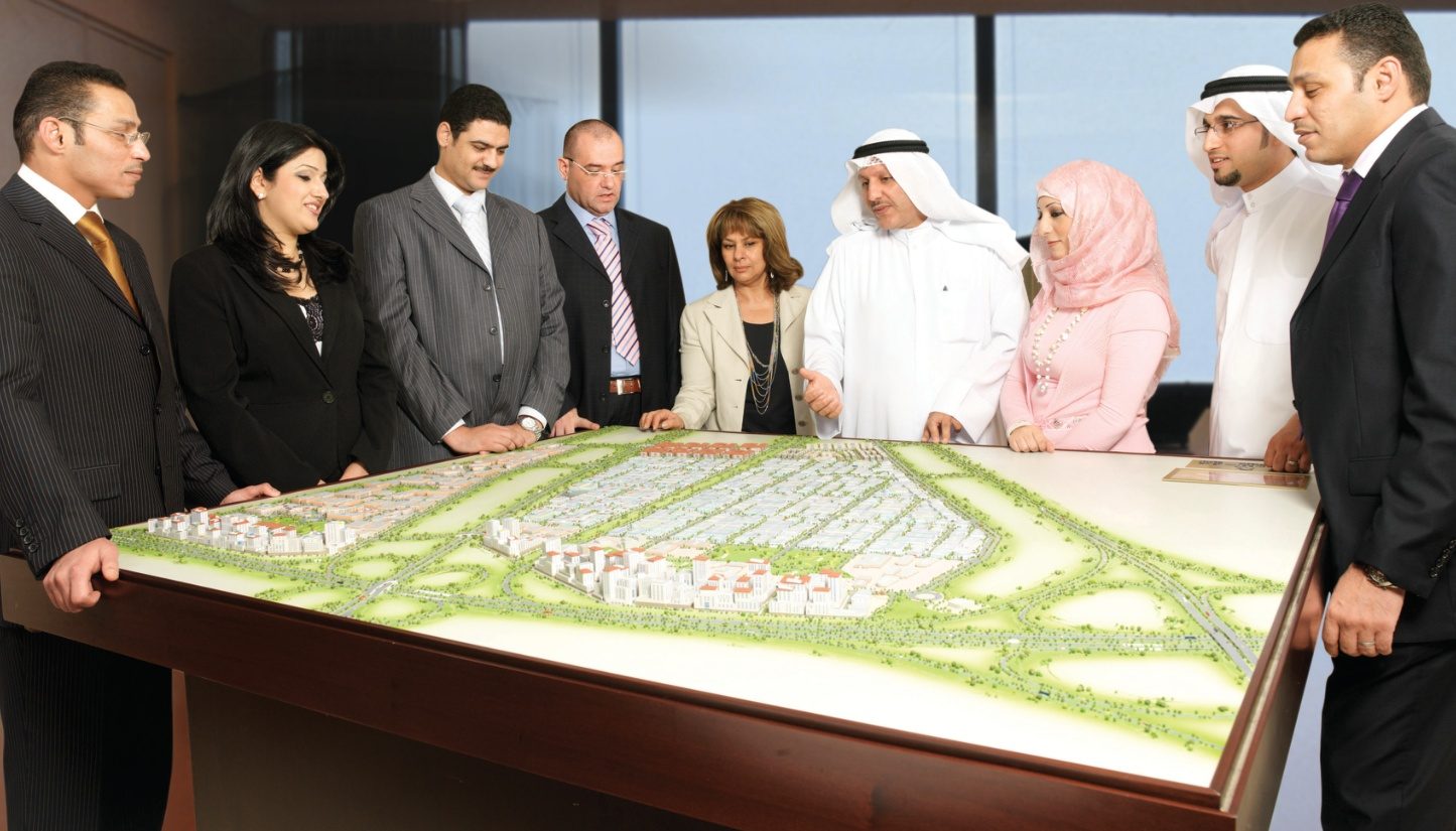 TREG team and clients standing around a masterplan model
